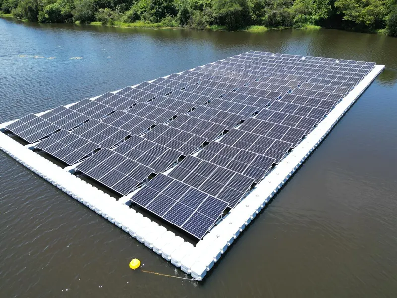Usina solar flutuante sobre a água de um reservatório, vista de cima