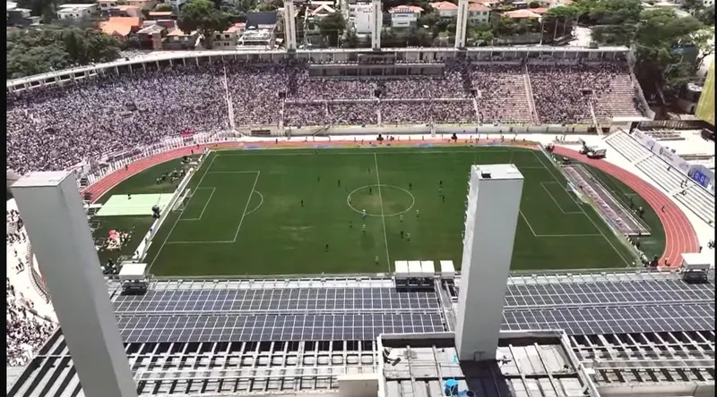 Painéis solares na cobertura da arquibancada do Pacaembu, com o campo e a torcida ao fundo