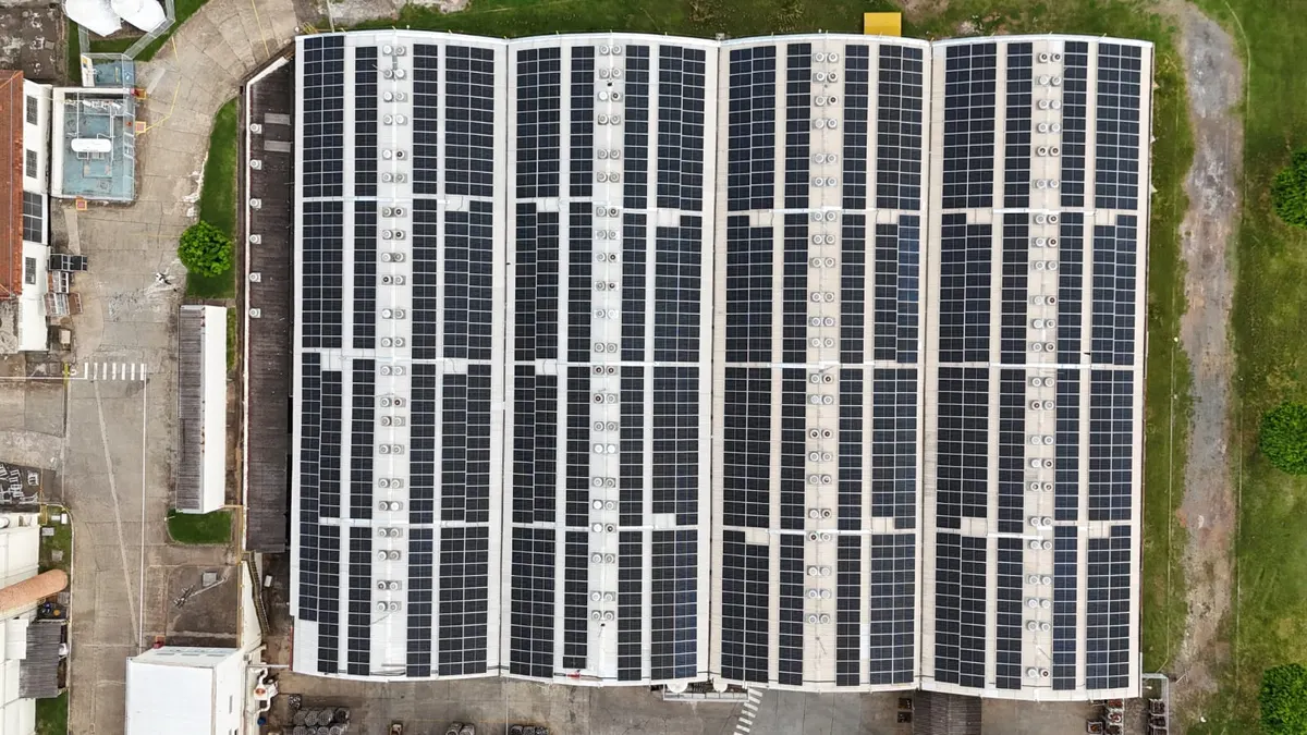 Telhado de galpão industrial da Zaccaria coberto de fileiras de painéis solares, visto de cima
